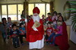 der Hl.Nikolaus im Kindergarten umringt von einer Gruppe Kinder