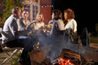 Symbolbild: Eine Gruppe von Menschen spätabends im Garten, im Vordergrund mit einem rauchenden Grill.
