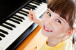 Symbolfoto: Mädchen, das vor einem Klavier sitzt