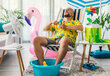 Mann sitzend in Wohnung mit Ventilator, die Füße im kühlenden Wasserbard